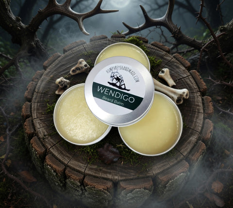 Three tins of Wendigo Beard Balm on a wooden surface with antlers and bones in the background.