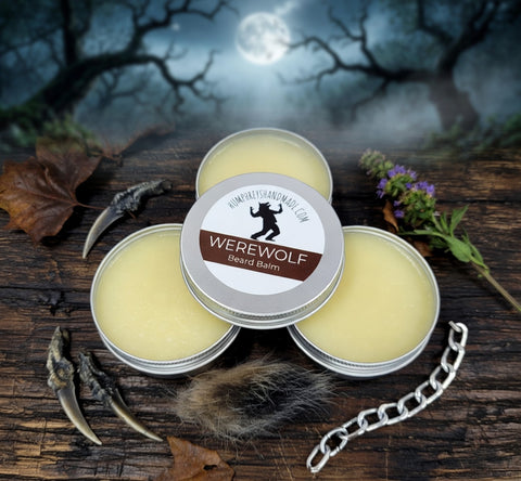 Three tins of Werewolf Beard Balm on a wooden surface with a moonlit night background.